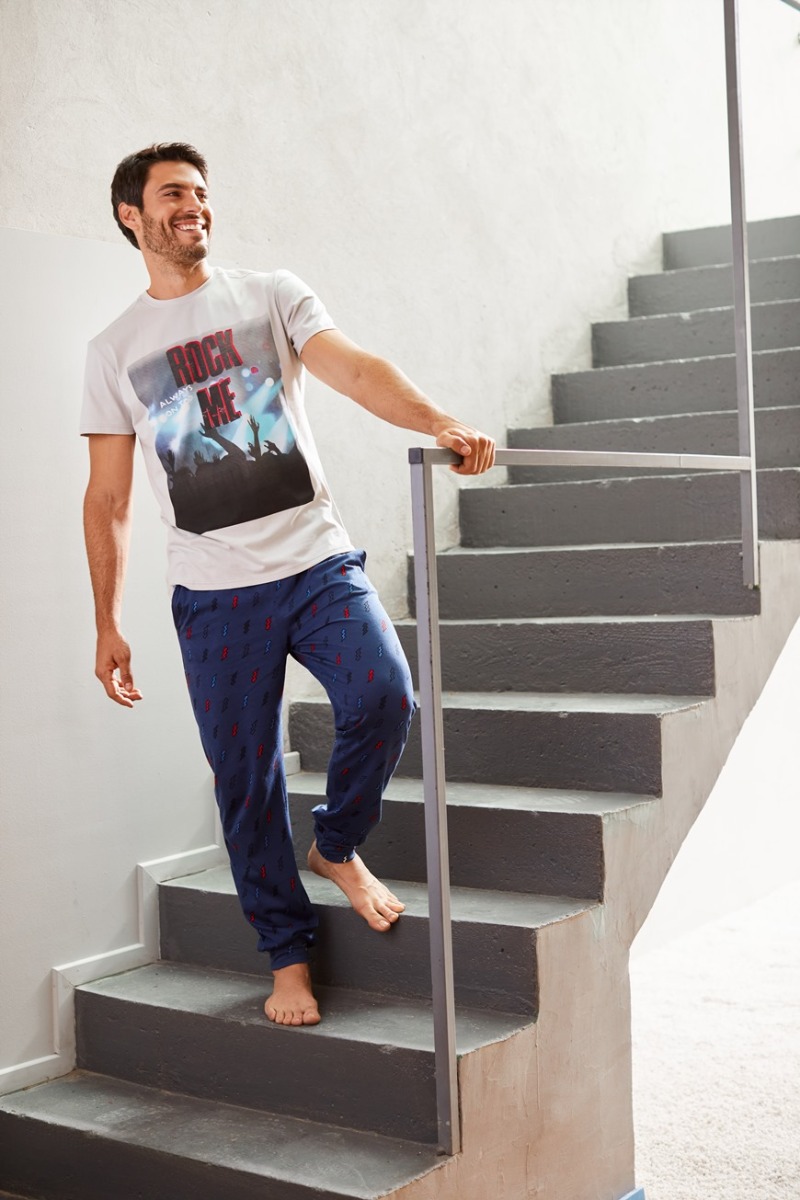 Muškarac koji stoji na stepenicama u pidžami